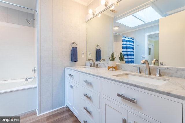 bathroom featuring shower / tub combo with curtain, wood-type flooring, a skylight, and vanity