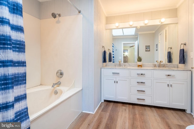 bathroom featuring vanity, hardwood / wood-style flooring, and washtub / shower combination