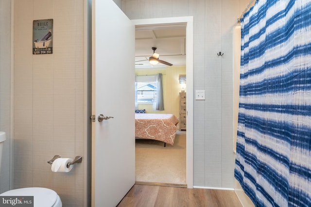 bathroom featuring wood-type flooring, ceiling fan, and toilet