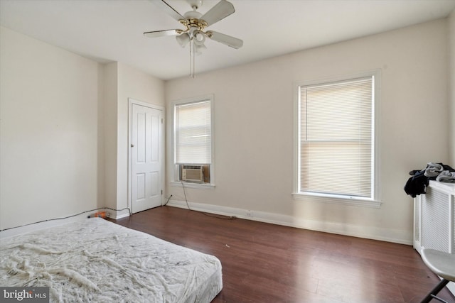 bedroom featuring dark wood-type flooring, ceiling fan, and cooling unit