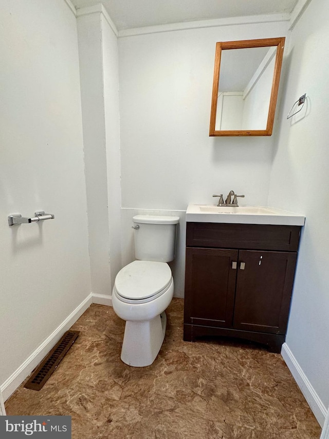 bathroom with vanity, crown molding, and toilet