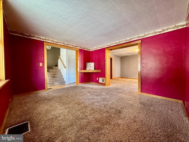 carpeted spare room with a textured ceiling