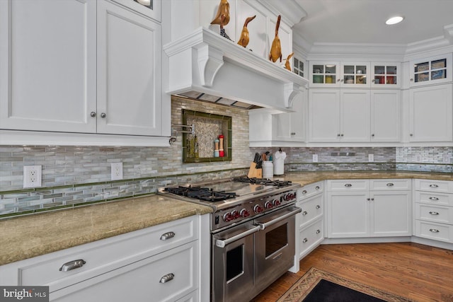 kitchen featuring range with two ovens, light stone countertops, and white cabinets