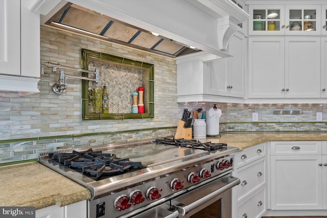 kitchen with range with two ovens, white cabinetry, premium range hood, and light stone counters