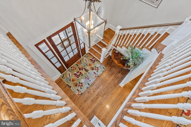 staircase featuring hardwood / wood-style flooring and a notable chandelier