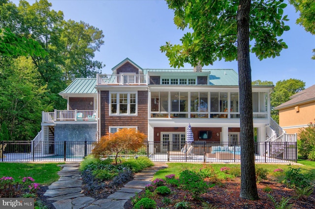 back of house featuring a fenced in pool and a balcony