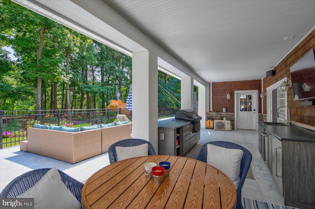 view of patio with area for grilling, sink, outdoor lounge area, and exterior kitchen