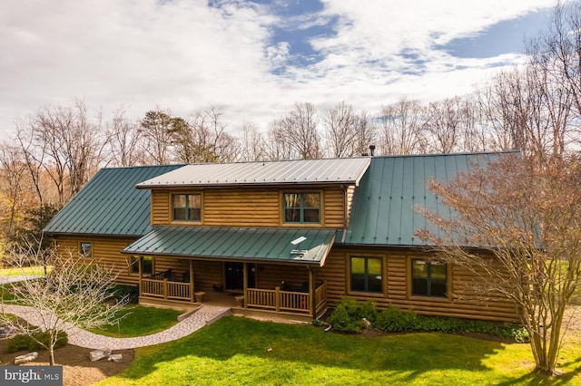 back of property with covered porch and a lawn