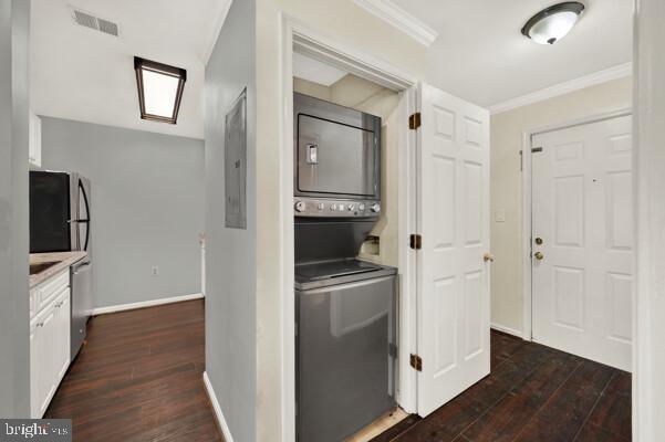 kitchen with visible vents, dark wood finished floors, ornamental molding, stainless steel appliances, and stacked washing maching and dryer