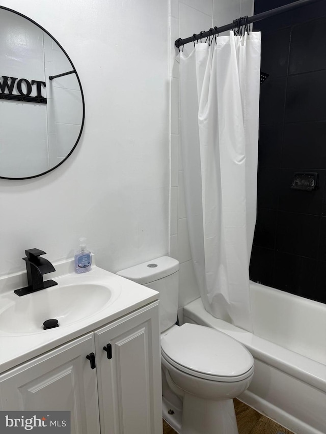 full bathroom with vanity, wood-type flooring, shower / bath combo with shower curtain, and toilet