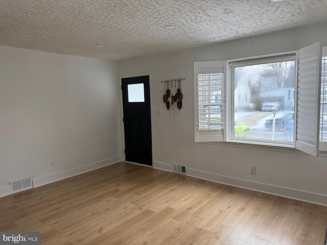 entryway featuring light hardwood / wood-style floors and a textured ceiling