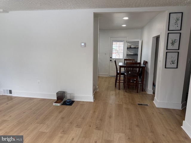 interior space with a textured ceiling and light wood-type flooring