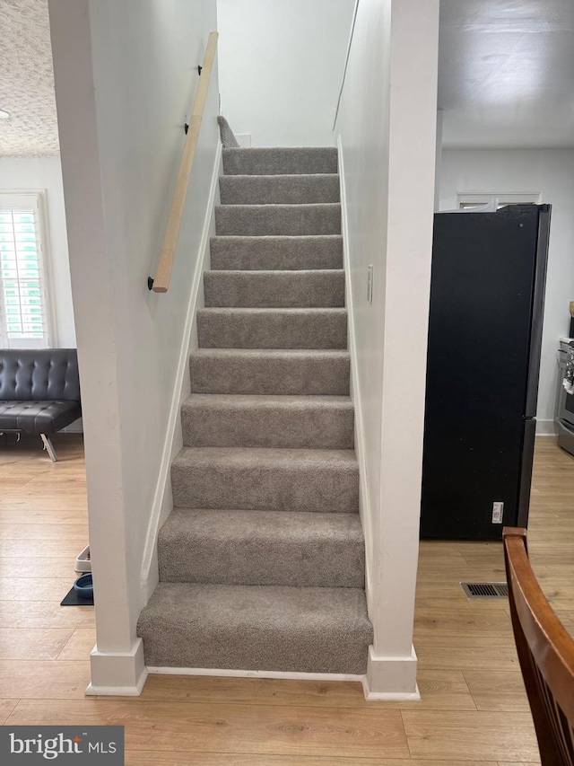 stairs with hardwood / wood-style floors