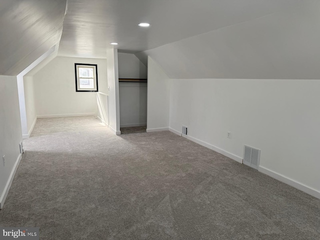 bonus room with carpet flooring and vaulted ceiling