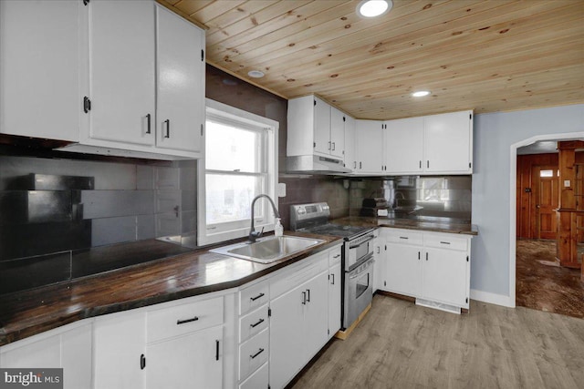 kitchen with sink, range with two ovens, wood ceiling, decorative backsplash, and white cabinets