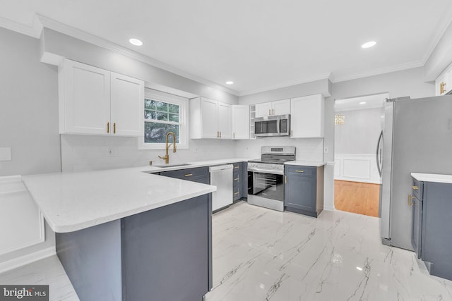 kitchen featuring a kitchen bar, sink, white cabinetry, appliances with stainless steel finishes, and kitchen peninsula