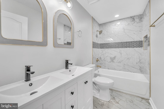 full bathroom with tiled shower / bath, vanity, and toilet