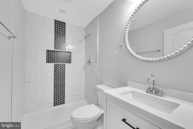 bathroom featuring vanity, a tile shower, and toilet