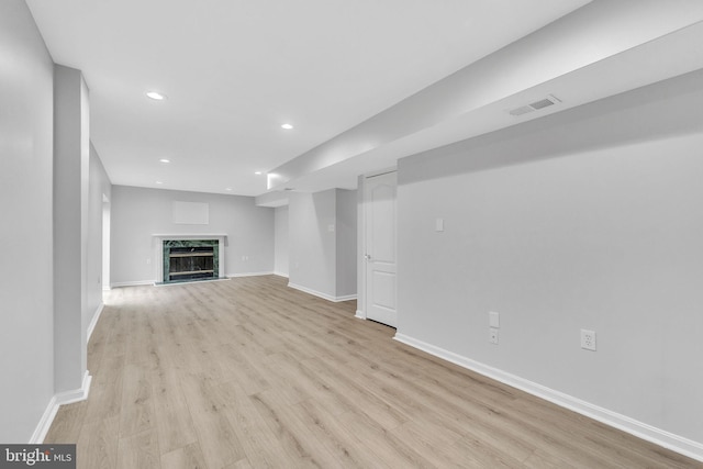 unfurnished living room featuring a high end fireplace and light wood-type flooring