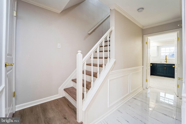 stairway featuring ornamental molding and sink