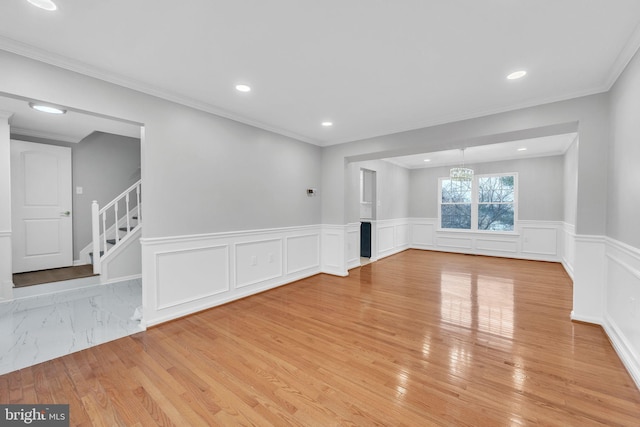 unfurnished living room with crown molding and light hardwood / wood-style floors