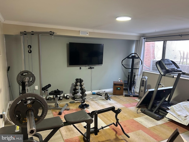 exercise area featuring crown molding