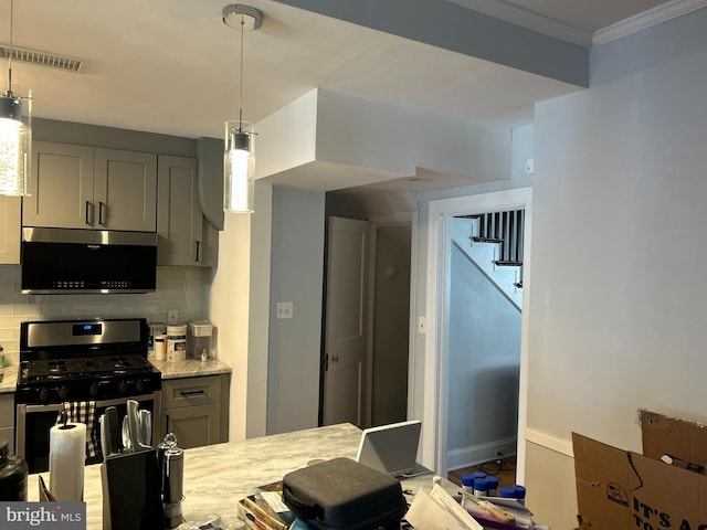 kitchen with decorative light fixtures, gray cabinetry, backsplash, stainless steel appliances, and crown molding