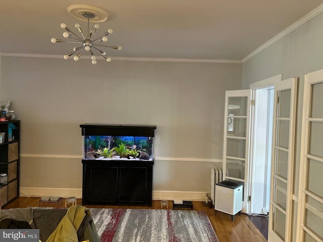 living room with hardwood / wood-style flooring, ornamental molding, and a chandelier