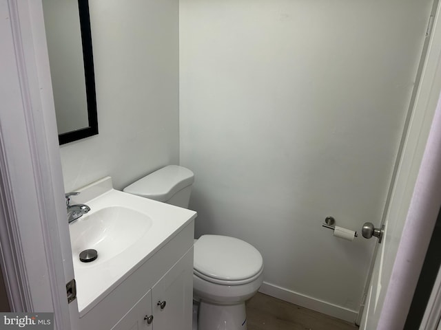 bathroom with vanity, toilet, and wood-type flooring