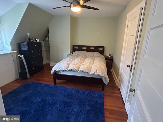 bedroom featuring dark hardwood / wood-style flooring, lofted ceiling, and ceiling fan