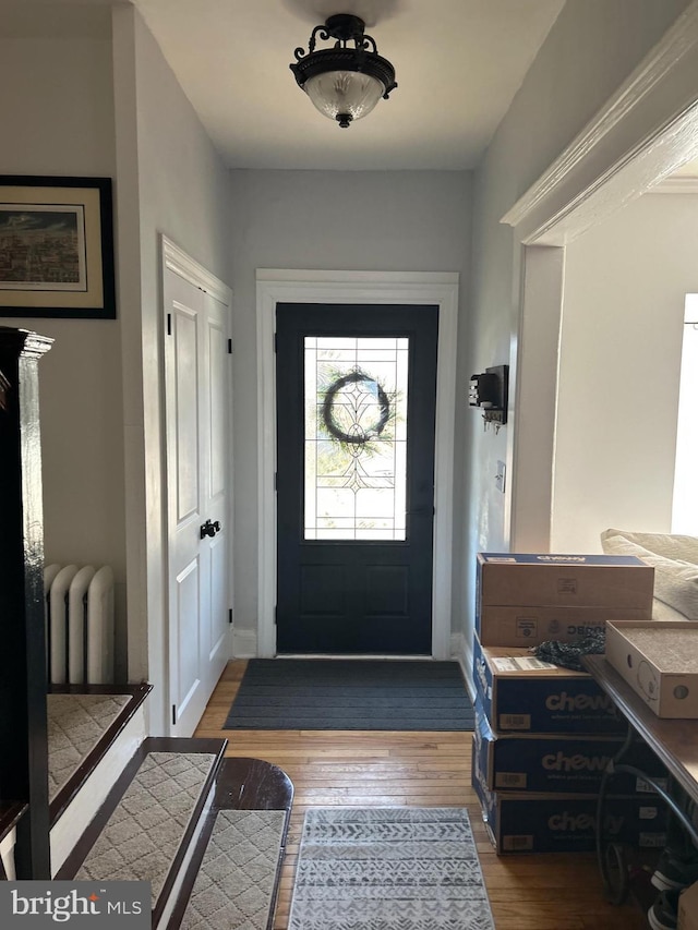 foyer entrance featuring radiator and wood-type flooring