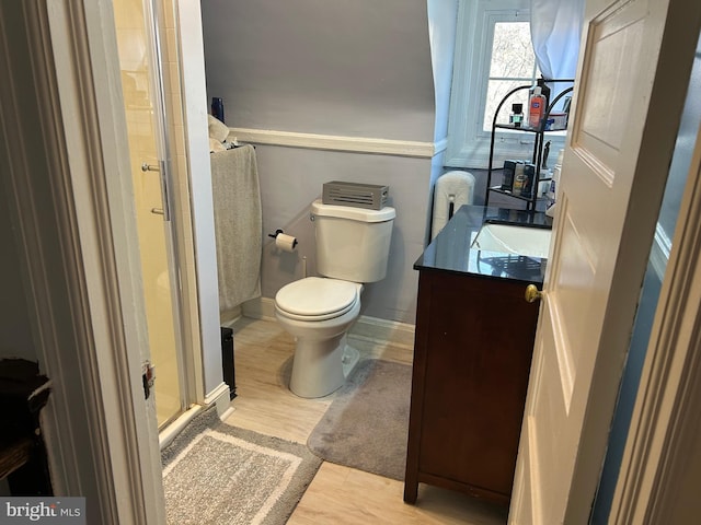 bathroom featuring hardwood / wood-style flooring, vanity, toilet, and an enclosed shower