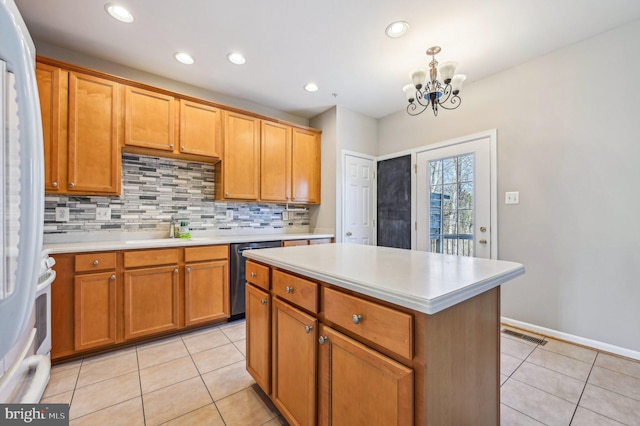 kitchen featuring white refrigerator, a center island, dishwasher, and light tile patterned flooring