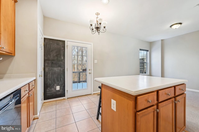 kitchen featuring light tile patterned flooring, a center island, black dishwasher, and plenty of natural light