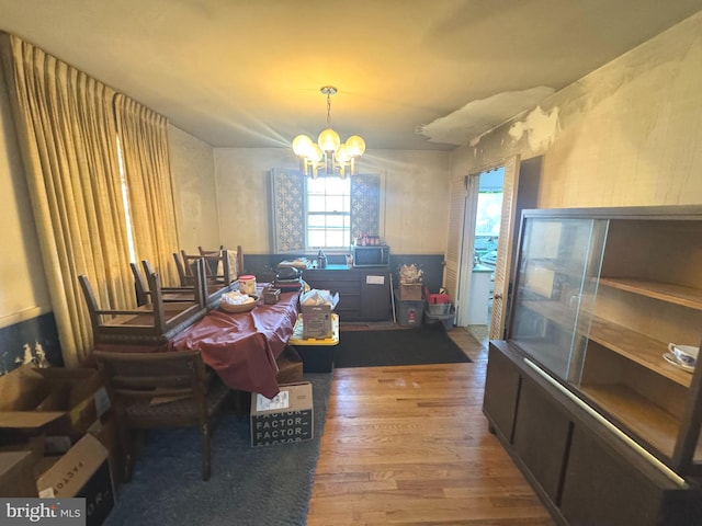 dining room with hardwood / wood-style flooring and an inviting chandelier