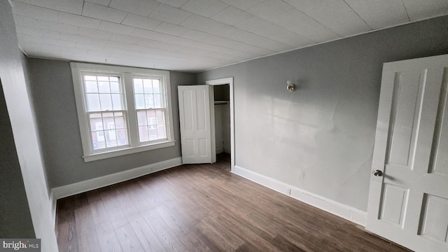 unfurnished bedroom featuring a closet and dark hardwood / wood-style floors