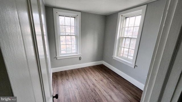 empty room with dark hardwood / wood-style flooring