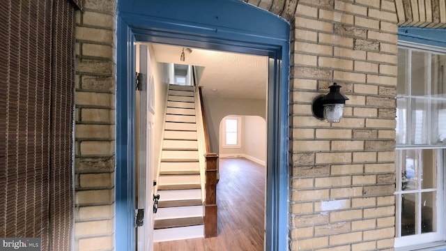 stairs featuring hardwood / wood-style flooring and a textured ceiling