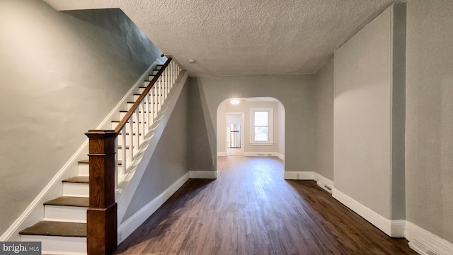 staircase featuring hardwood / wood-style flooring and a textured ceiling