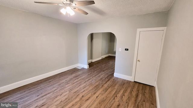 spare room with dark wood-type flooring, a textured ceiling, and ceiling fan