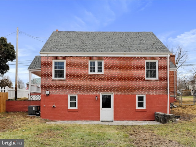 rear view of property featuring a yard and central AC