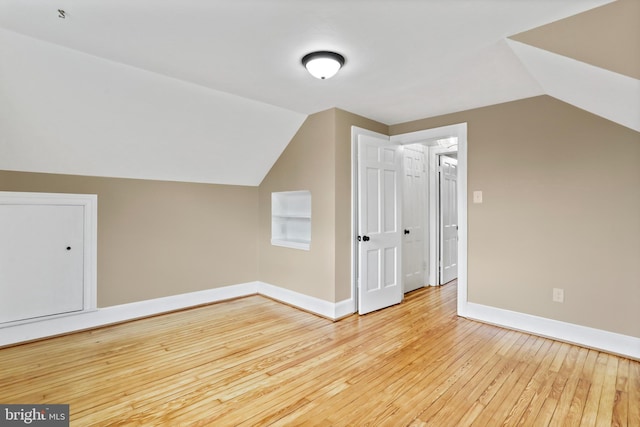 bonus room with light hardwood / wood-style flooring and vaulted ceiling