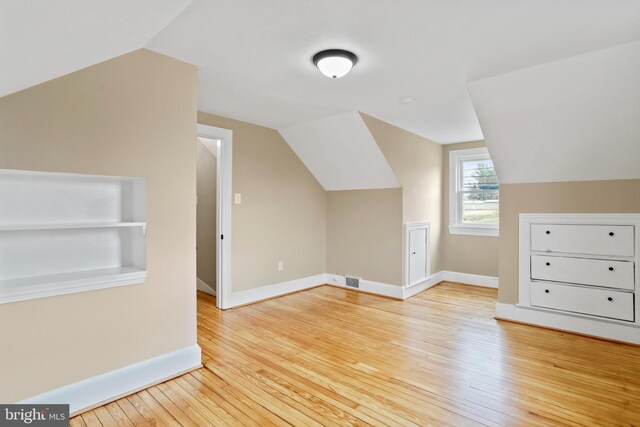 additional living space with lofted ceiling and light hardwood / wood-style floors