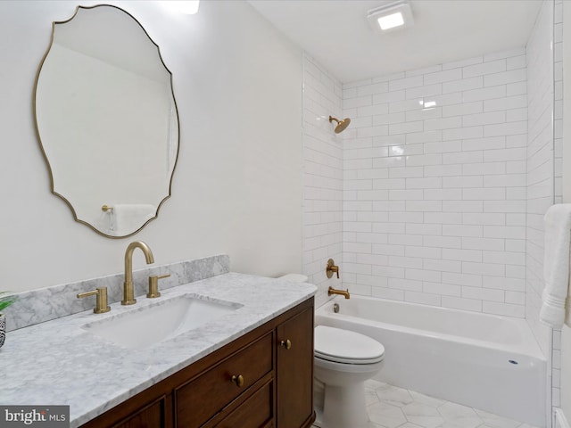 full bathroom with vanity, tiled shower / bath combo, and toilet