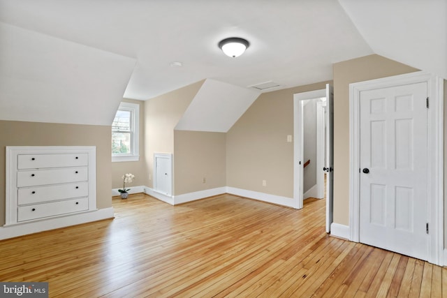 bonus room featuring lofted ceiling and light wood-type flooring