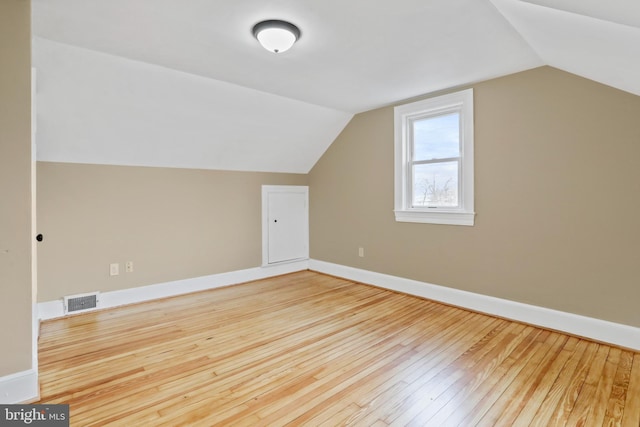 additional living space featuring hardwood / wood-style flooring and vaulted ceiling