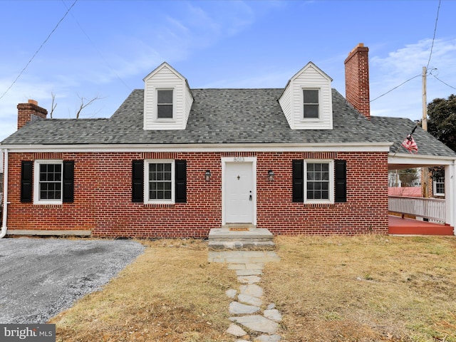 cape cod home with a front lawn