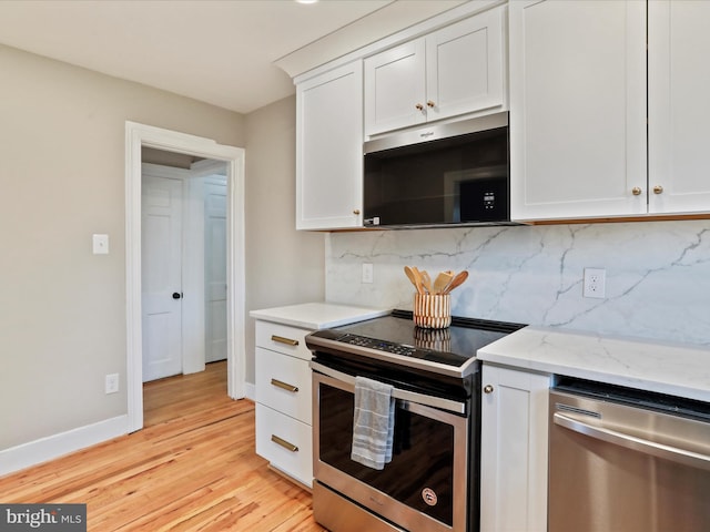 kitchen featuring stainless steel appliances, light stone counters, white cabinets, decorative backsplash, and light wood-type flooring