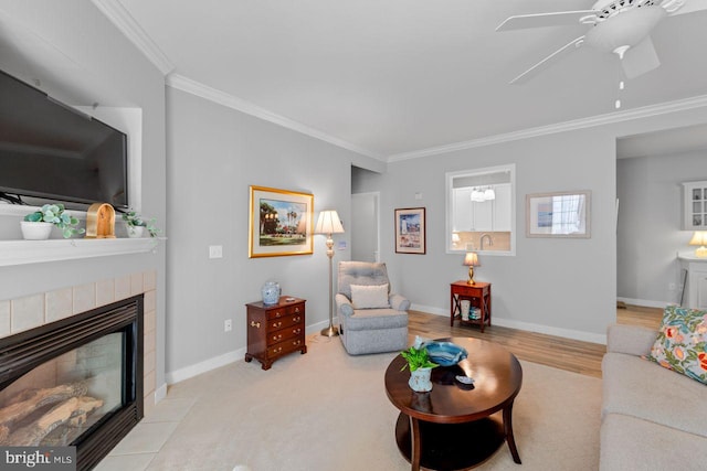 living room with ceiling fan, ornamental molding, and a tile fireplace