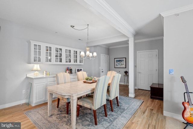 dining space with crown molding, light hardwood / wood-style floors, a chandelier, and beamed ceiling